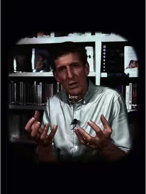 The cover image shows a man with short brown hair, wearing a light-colored button-down shirt, speaking directly to the camera. Behind him are bookshelves filled with books. The word love is superimposed in a white font over his chest, and the overall composition is framed within a dark vignette.