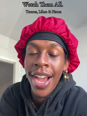 The cover image presents a close-up of a person with dark skin wearing a red satin bonnet. The person's eyes are closed, and their mouth is slightly open, suggesting they are speaking or singing. They have gold hoop earrings with dangling charms of different colors. A black hoodie is visible, and the background is a neutral wall. Text overlays at the top provide the hook.