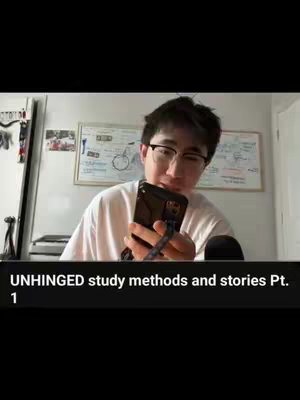 A young man with glasses is holding a phone and looking at it with a slight smile; text is placed on a black bar in the bottom