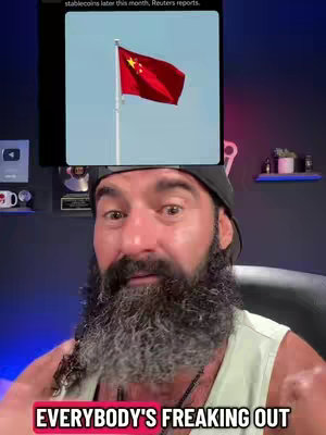 The cover image is a selfie-style shot featuring a man from the chest up. He has a full, graying beard and is wearing a black hat and a light green undershirt. The background is a combination of a dark setting with blue and purple ambient lighting. Overlayed on the creator's face is a screenshot of a news report related to the Chinese flag. Additionally, a text overlay at the bottom of the screen reads, "EVERYBODY'S FREAKING OUT".