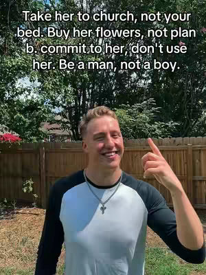 A smiling young man with blonde hair points his index finger upwards. He's wearing a black and white baseball long sleeve shirt and a silver necklace with a cross pendant. Behind him is a wooden fence and trees. The background is slightly out of focus. The text overlay is black on a white background with the message of the text.