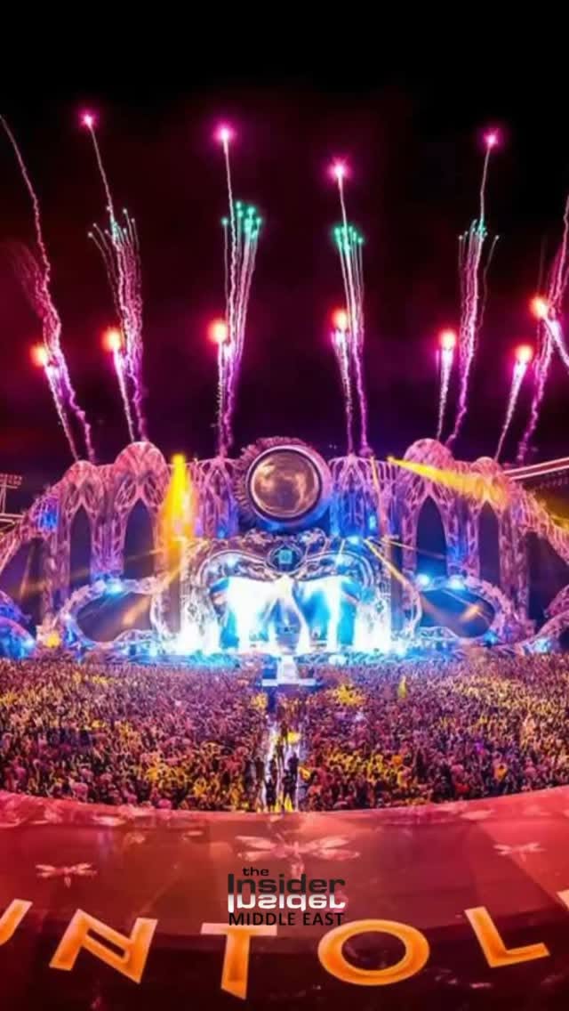 The image captures a vibrant music festival scene at night. The focal point is a massive stage with elaborate architectural design, illuminated with bright blue and white lights. A large crowd of people is gathered in front of the stage. Above the stage, colorful fireworks are exploding in the dark sky, creating a festive atmosphere. The logo for 'The Insider MIDDLE EAST' is placed in the lower center.