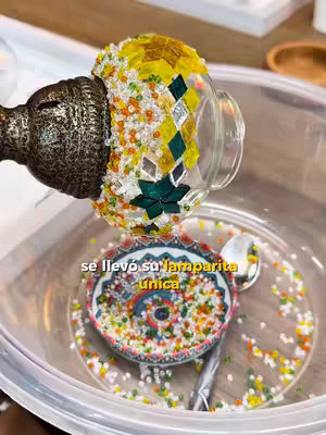 The cover image showcases a close-up view of a decorative Turkish lamp disassembled. The lamp has a mosaic glass shade with yellow, green and clear mosaic pieces. A small decorative bowl, covered in various color beads is captured at the bottom. Additional scattered beads and a tarnished metal stem are also visible. The image has a warm and artisanal feel.