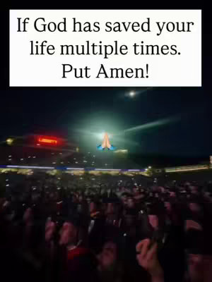 The image shows a nighttime view of a large gathering of people, likely at a concert or event, with a bright sky featuring a stylized image of hands in prayer. Overlayed text appears at the top.
