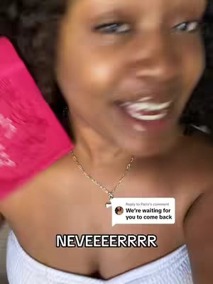 A close-up selfie of a young woman, captured in a bright and softly lit environment. She has dark, curly hair and is smiling widely, showcasing her teeth. The woman wears a white top that is only partially visible, and a gold chain with a pendant around her neck. To the left, a bright pink shape is visible. A speech bubble with text appears at the bottom right of the cover image.