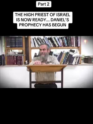 A man with a long white beard is sitting behind a wooden table. There are bookshelves in the background filled with books. Overlayed text says 'Part 2' and 'THE HIGH PRIEST OF ISRAEL IS NOW READY... DANIEL'S PROPHECY HAS BEGUN'.