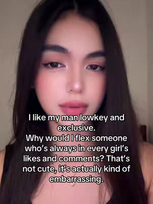 A selfie-style video cover image featuring a light-skinned woman with long, dark hair. She has a soft, pink blush applied, dark eyeliner, and light pink lip color. The background is a plain, light-colored wall. Text overlayed near the bottom contains the content hook.