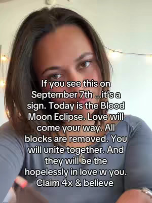 A woman with brown hair and a grey shirt is looking at the camera. Text is overlayed on the video.