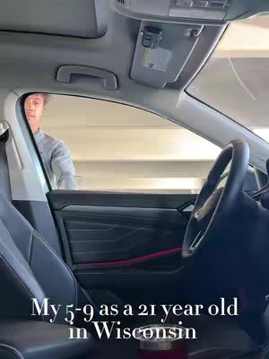 View from inside a car looking out at the exterior and seeing a person standing next to the car. The view is from the driver's seat, and a red thermal cup can be seen in the cupholder. The text overlay at the bottom says: My 5-9 as a 21 year old in Wisconsin.