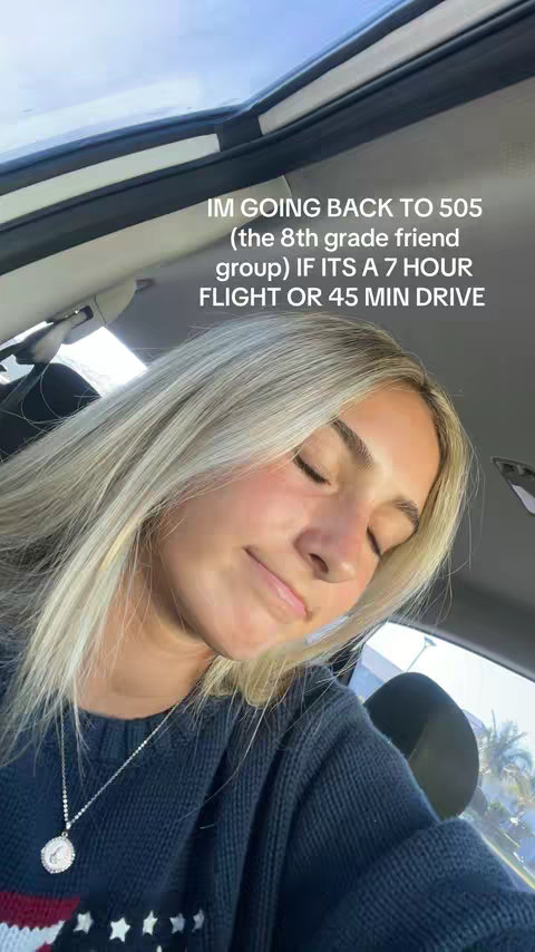 The cover image features a young woman with blonde hair sitting in the driver's seat of a car. She is wearing a dark blue sweater. The text overlayed reads "IM GOING BACK TO 505 (the 8th grade friend group) IF ITS A 7 HOUR FLIGHT OR 45 MIN DRIVE."