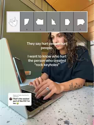 A woman with dark hair is seated at a desk, typing on a laptop. She has visible tattoos on her arm and is wearing a black t-shirt. On the upper portion of the screen, there's a diagram of shapes. Below, text overlays provide commentary on the image and its content. The laptop screen reflects a light source, and a secondary screen is open at the back. A comment box from another user is on the bottom left. The background is a muted green, suggesting an indoor environment.