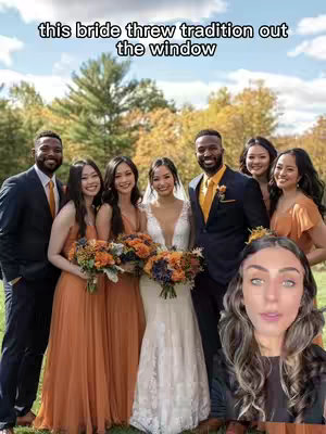 A group photo featuring a wedding party. The bride, in a white dress, stands in the center, surrounded by bridesmaids in orange dresses and groomsmen in dark suits. The background shows a lush, green outdoor setting with trees and hints of golden autumn leaves. A female creator is in the foreground.