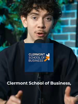 A young man with curly hair is centered in the frame, speaking towards the viewer. Behind him is a blurry green background, and a dark brick wall is partially visible on the right. A square graphic with the Clermont School of Business's logo overlays his chest, with text at the bottom.