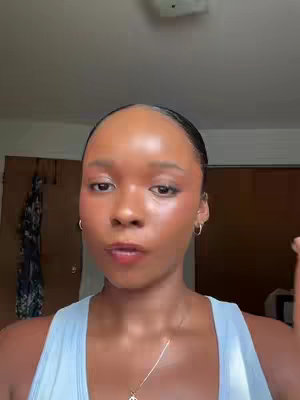 The cover image shows a close-up of a young woman's face, with the camera at eye-level. She has clear skin with minimal makeup, including eyeshadow and blush. She wears small hoop earrings and a delicate necklace and a light blue top. Her hair is pulled back. The background includes a white ceiling and a partly visible door.