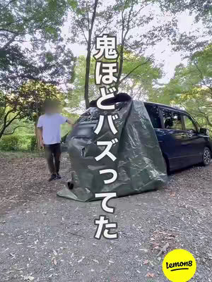 The image shows a person standing next to a minivan, with a large green tarp draped over the back of the vehicle, creating a makeshift tent. Text in Japanese is vertically aligned on the left side of the tarp, and the Lemon8 logo is in the lower right corner.