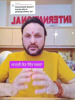 A man with a beard and a red mark on his forehead, wearing a yellow shirt, speaking directly at the camera with a purple text box overlayed in the bottom, left corner. The background includes a sign that reads 'INTERNATIONAL' and a wooden shelf.