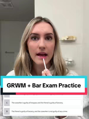 A woman looking directly at the camera while applying lip gloss with a wand applicator. A text overlay at the bottom features an exam question and answer choices. The background is a bathroom setting, with a mirror and basic toiletries visible.