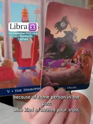 The cover image features two tarot cards held in a person's hands. One card displays a building or monument, while the other features a cloaked figure with a flag. Text overlays the cards, offering the Libra zodiac sign.