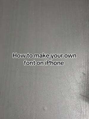 The cover image is a grayscale photo with a textured background, likely a wall or surface. Centered on the image is a text overlay in a clean, sans-serif font that says, "How to make your own font on iPhone."