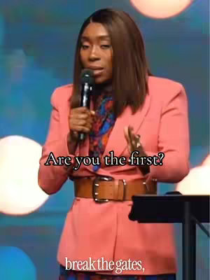 The cover image shows a woman speaking into a microphone on a stage. The background includes blurred lights, and superimposed text. The woman is wearing a pink blazer, and a belt.