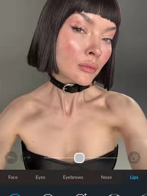 A woman with a pale complexion and dark, short hair poses for a selfie. She wears a black choker and a strapless top. The image is a close-up, focusing on her face and the app interface at the bottom, with editing options like 'Face', 'Eyes', and 'Lips' visible.