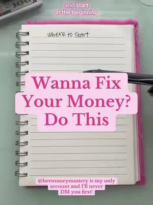 An overhead shot shows an open notebook with a pink cover on a light-colored surface, possibly a desk. The notebook has lined pages. Overlaid on the notebook is a pink rectangle with the text "Wanna Fix Your Money? Do This". Smaller text bubbles above and below the main text add additional phrases. A pen is resting on the notebook.