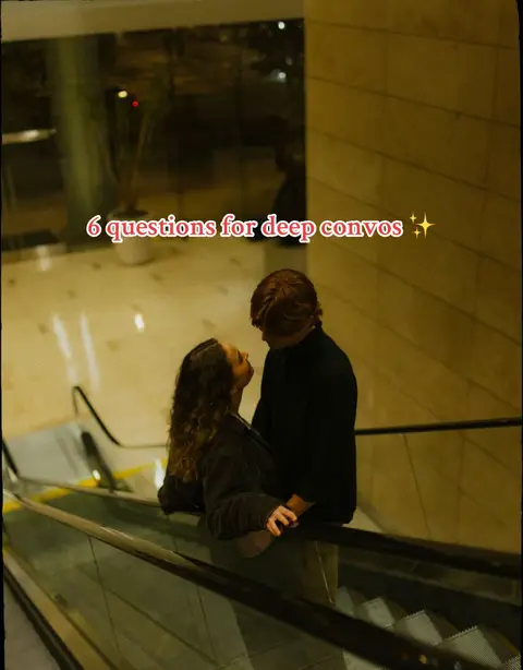A couple stands close on an escalator, gazing at each other. The shot is from a low angle, looking up at them. The environment has a warm, dim lighting with neutral tones, and the text overlay is placed at the top center.