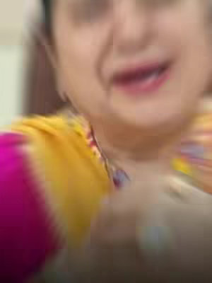 The cover image is a slightly blurred, close-up shot of a person, likely a woman, from the shoulders up. She is wearing a pink and yellow outfit. Her face is slightly out of focus, but her lips are visible and she might be smiling. The background seems to be an interior space, though it is also blurred.
