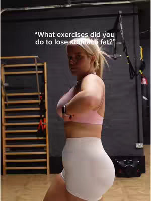 A fitness-focused image featuring a woman in workout attire, likely in a gym environment. The lighting appears to be from the front, highlighting her form, with text overlaid at the top. The composition focuses on the creator, showcasing her physique and setting.