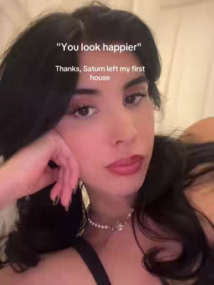 A close-up shot of a woman with dark hair, dark eyes, and red lipstick, leaning on her hand. Text overlays are present at the image's top.