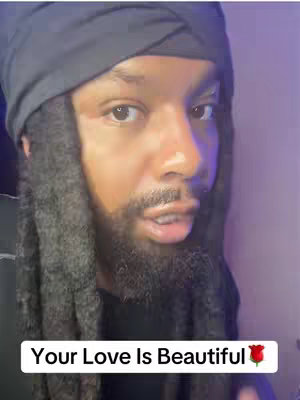 A close-up shot of a Black man with a beard, wearing a black head wrap. He has a serious expression, and text at the bottom reads 'Your Love Is Beautiful' with a rose emoji.