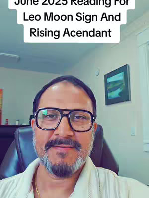 A man with glasses and a mustache is centered in the frame, with text overlaid at the top. The background includes interior elements and a window.
