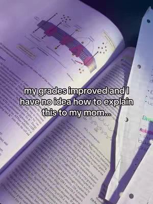 An open textbook on a desk, with a diagram of a biological process and handwritten notes visible. Text overlays read "my grades improved and I have no idea how to explain this to my mom...". The overall color scheme is muted, with a purple tint.