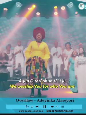 A woman in a yellow top and patterned skirt stands on a stage, singing in front of a crowd. Text overlays in English and another language are placed strategically.