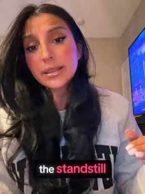 The cover image features a woman speaking directly towards the camera. She has long, dark hair and is wearing a light-colored sweater. Text overlayed on the image reads 'the standstill'. In the background to her right, a television screen is partially visible.