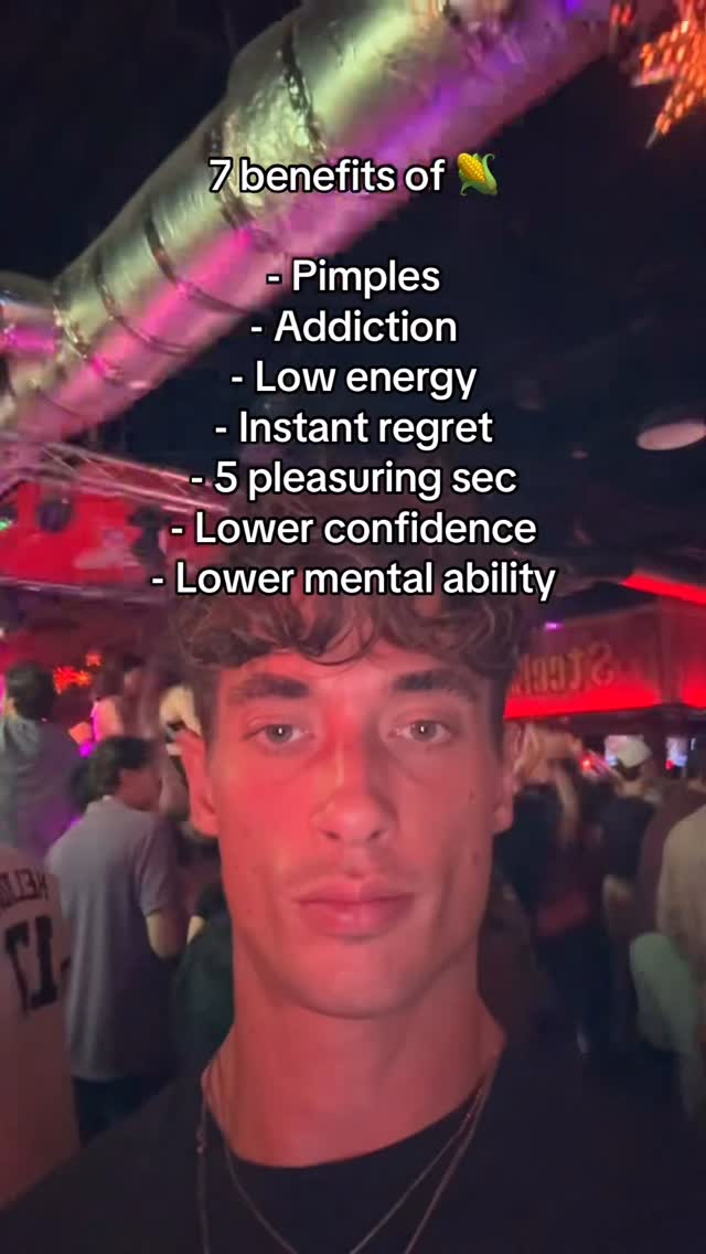 A selfie-style video cover with a young man in the foreground. The background is a blurred nightclub or bar setting with people and bright lights. Text overlays list '7 benefits of 🌽' followed by negative effects.
