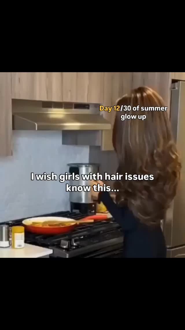 A person is standing the kitchen with their back to the camera. Text overlays on the image.