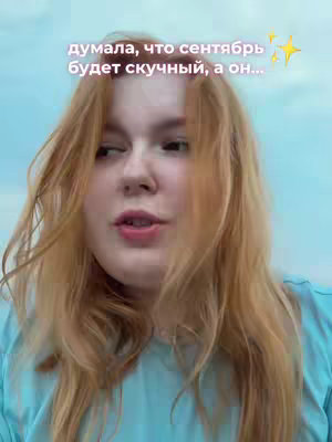 A young woman with long, light-red hair is looking slightly off-camera and speaking. Text is overlaid, and there are sparkly star emojis in the background.