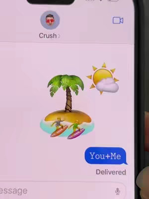 A screenshot of a phone screen displaying a message app. The background is a light pink color. The top left of the screen displays a profile picture of a face with sunglasses and the word 'Crush'. In the middle of the screen are emojis of a palm tree and sun with a cloud and two surfers on a small island. At the bottom is a blue speech bubble that says 'You+Me' and 'Delivered' below that.