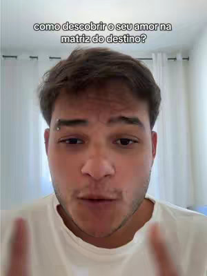 A man is centered in the frame, gazing directly at the viewer with a neutral expression. Above him, text is visible. The background is out of focus, suggesting an indoor setting, with what appears to be a curtain visible.