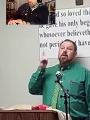 A man with a beard and a green short-sleeved shirt raises his index finger while speaking into a microphone at a podium. Off to the side is a smaller inset image of another man in a black shirt operating a microphone and audio mixing board. Behind the main man is a poster board with text that is difficult to read at this resolution. 