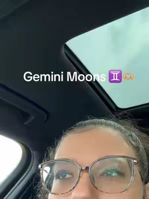 The cover image shows the top half of a person's face wearing glasses, looking up, with the text 'Gemini Moons' overlaid. Part of a car's interior, including the sunroof, is visible in the background, with a cloudy sky seen through the sunroof.