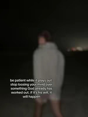 A blurry, dark image of a person standing outdoors at night, facing away from the camera. The person is wearing a hooded sweatshirt. Overlayed text is visible at the bottom.