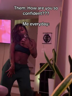 A woman in a casual outfit is taking a mirror selfie, with a conversational text overlay on the image. The lighting appears soft and the composition includes elements like indoor decor to establish the setting.