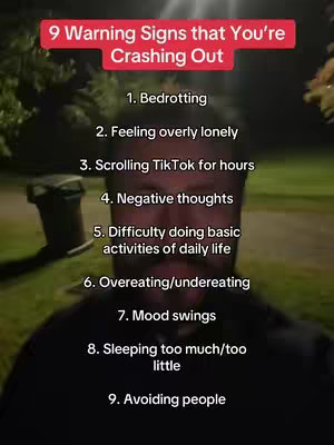A low-angle selfie-style shot, focusing on a man with a blurred background. Overlayed on the image is a list of '9 Warning Signs that You're Crashing Out'. The list is centered, taking up most of the frame with the man’s face partially visible. The background is dark with some green trees, suggesting an outdoor evening setting.