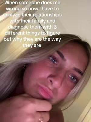 A selfie-style shot featuring a young woman with blonde hair, turned slightly to her left. She is looking at the camera with a slightly pursed lip expression. The background appears to be a soft, warm yellowish light. Text overlayed on the image provides additional context.