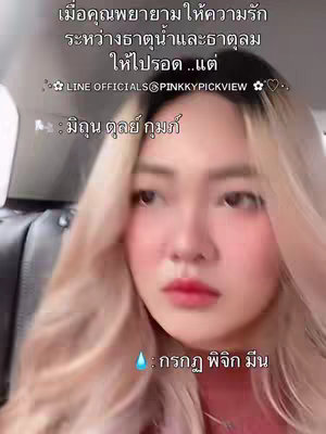 A close-up shot of a woman with light skin and blonde hair, looking directly at the camera. The background is blurred, suggesting an interior setting, possibly a car. Text overlays are incorporated, including astrological symbols and Thai text.