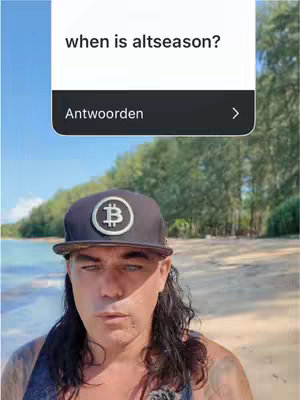 A man with long hair and a Bitcoin cap is posing on a beach with a blue sky at the background. A vertical white text overlay highlights the question 'when is altseason?' with a reply button below.