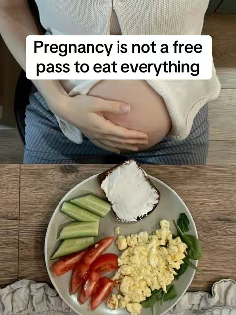 The cover image shows a pregnant woman in the upper part of the image, emphasizing her belly. The woman is wearing a white sweater and holding her belly with her hands. Below, a plate with a meal: scrambled eggs, sliced tomatoes, cucumber slices next to a piece of bread coated in cream cheese. The background is of a wooden table and countertop.