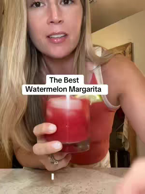 A woman with long blonde hair holds a glass of red drink. The text overlay says: 'The Best Watermelon Margarita'.